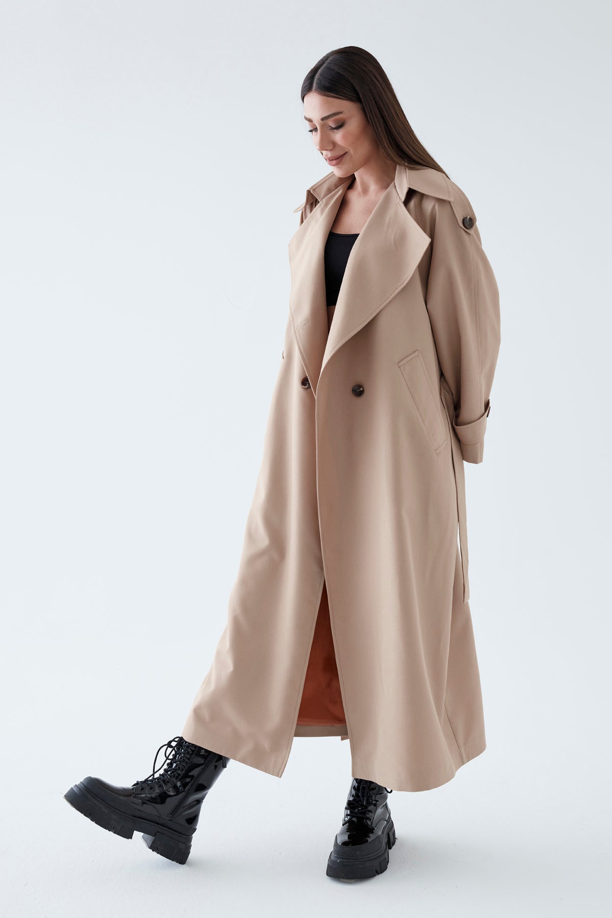 Woman wearing a beige trench coat on a white background