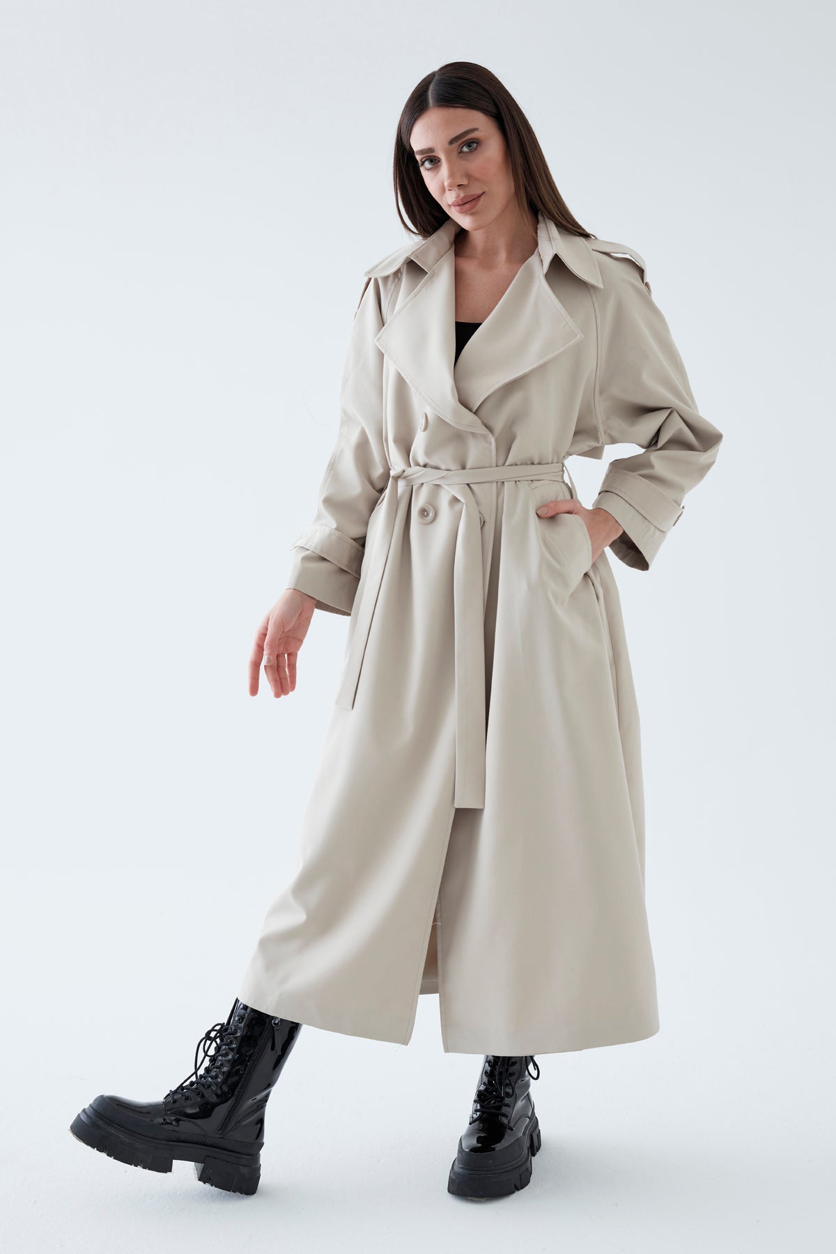 Woman wearing a beige trench coat on a white background
