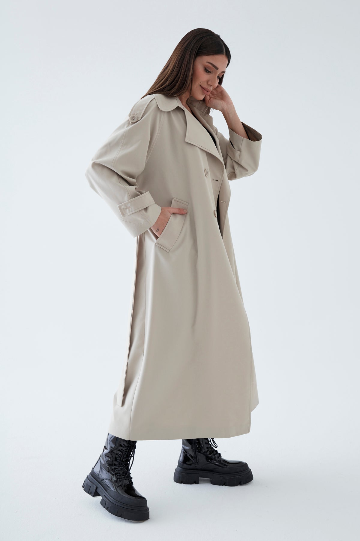Woman wearing a beige trench coat on a white background