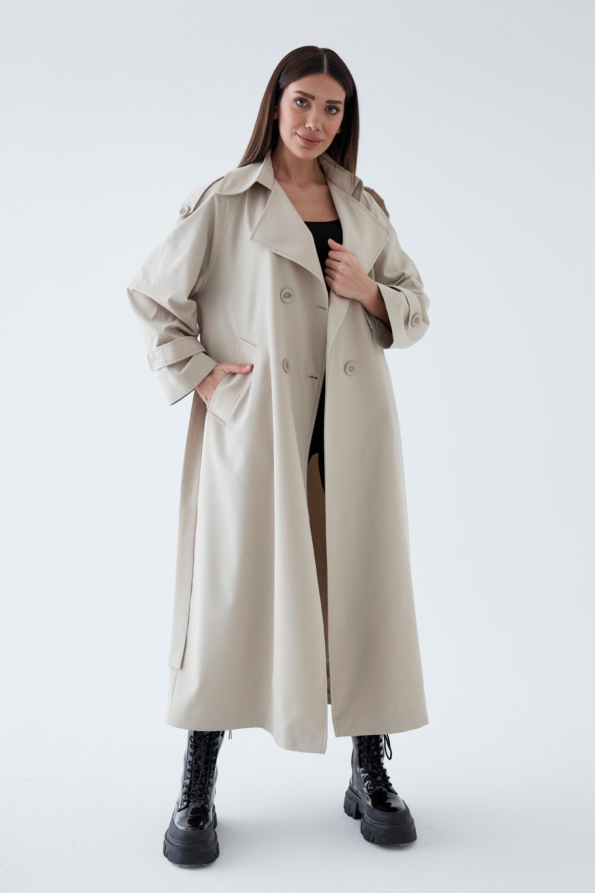 Woman wearing a beige trench coat on a white background